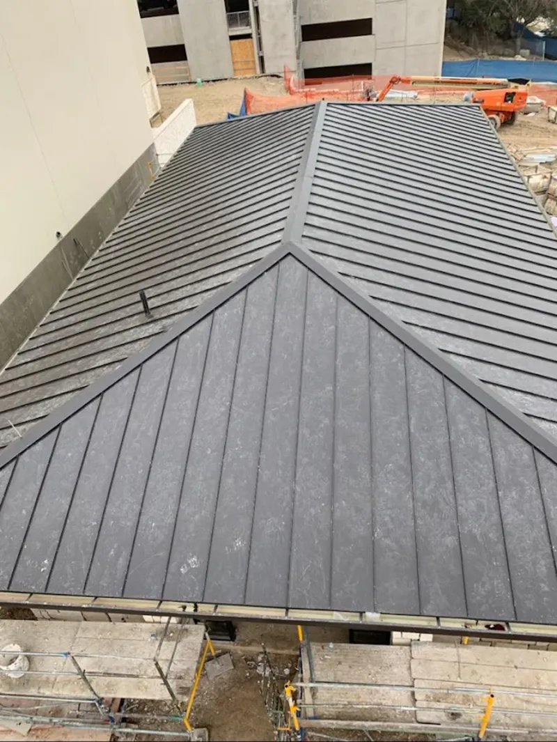 Commercial metal roof construction with crane equipment in Semmes